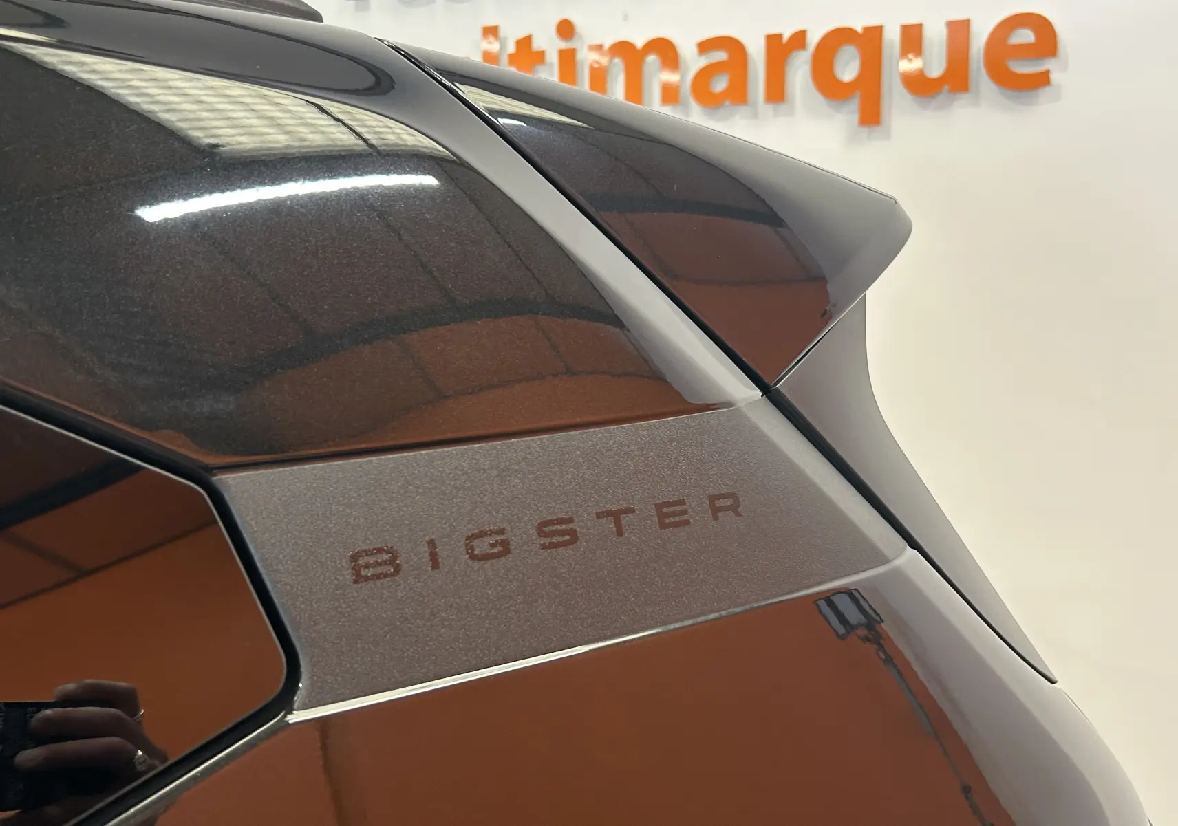 Détail du hayon arrière noir nacré du Dacia Bigster 2026 avec logo BIGSTER en gros plan, vue côté droit.