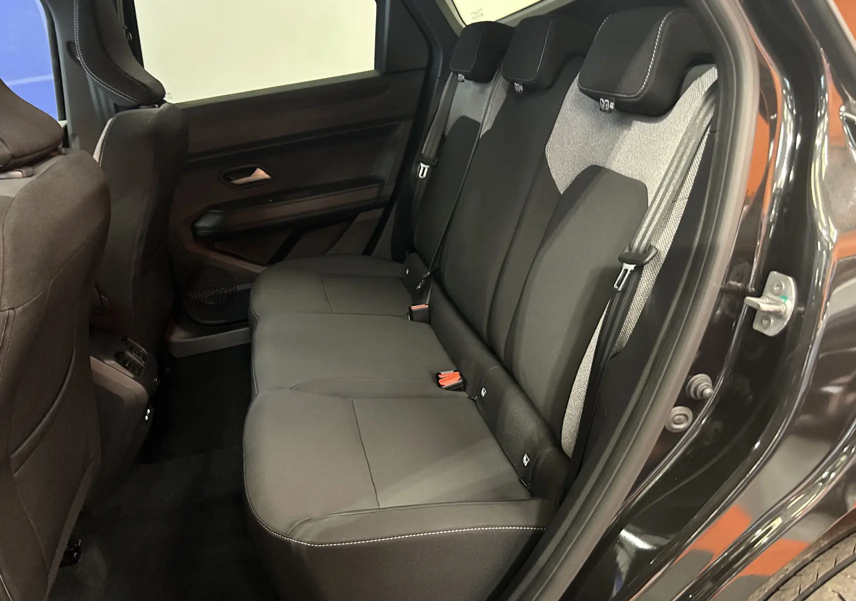 Vue intérieure côté droit sur la banquette arrière en tissu gris et noir du Dacia Bigster noir nacré 2026.