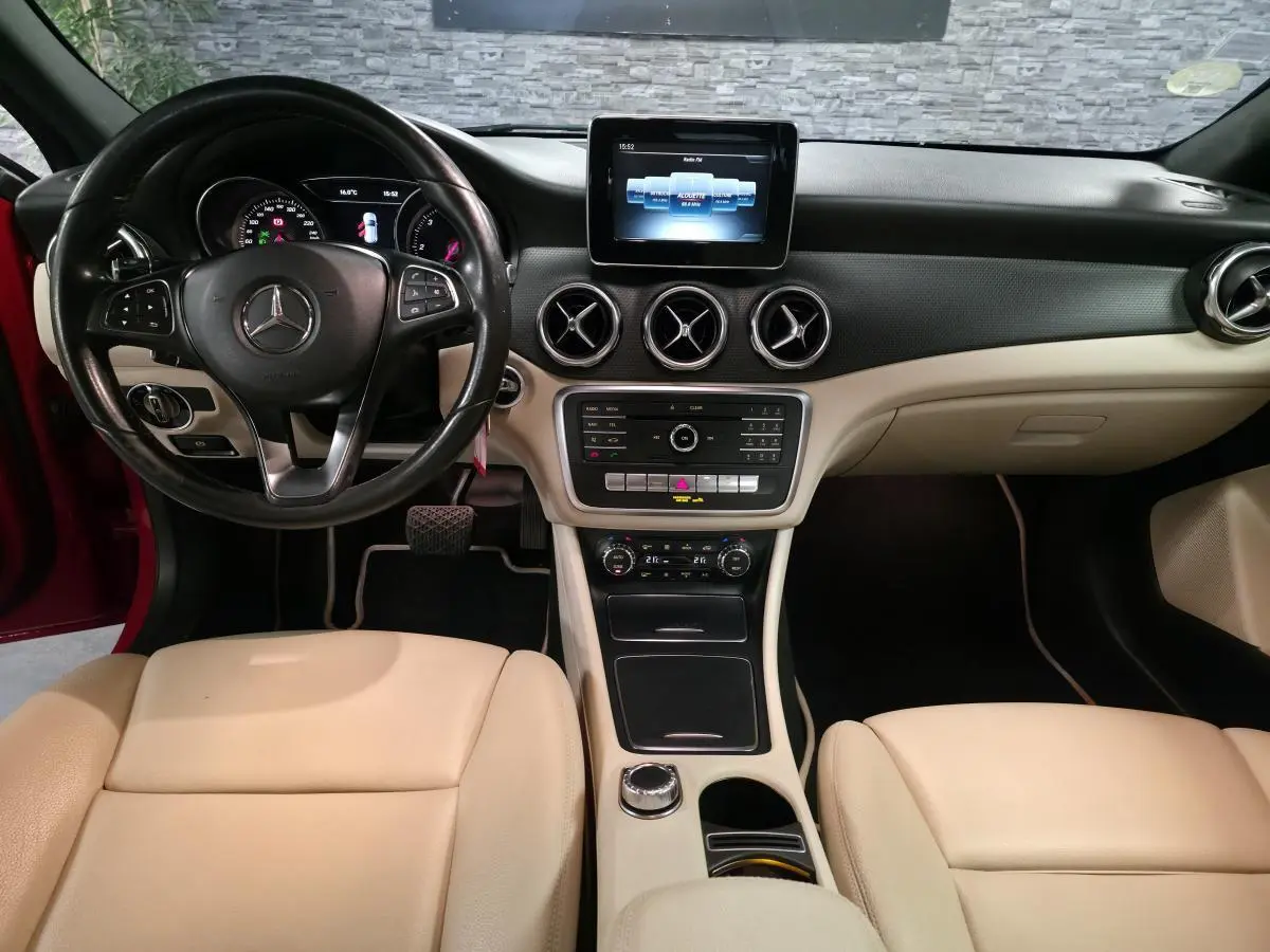 Intérieur beige et noir de Mercedes GLA 200 d 2017, vue de face sur le tableau de bord et volant multifonctions cuir.