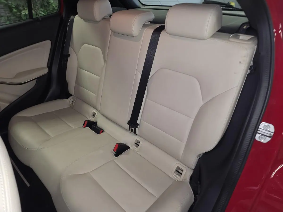 Vue intérieure arrière côté droit montrant la banquette beige clair du Mercedes GLA 200 d rouge avec ceinture noire.