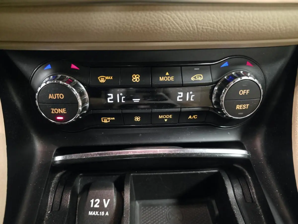 Panneau de climatisation automatique bicolore avec réglages digitaux à 21°C dans Mercedes GLA 200 d rouge, vue intérieure rapprochée.