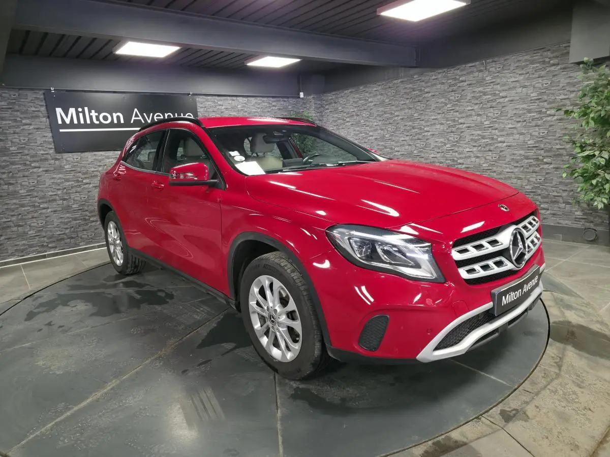 Mercedes GLA 200 d rouge vue 3/4 avant droit, avec jantes alliage argent et calandre chromée, en showroom.