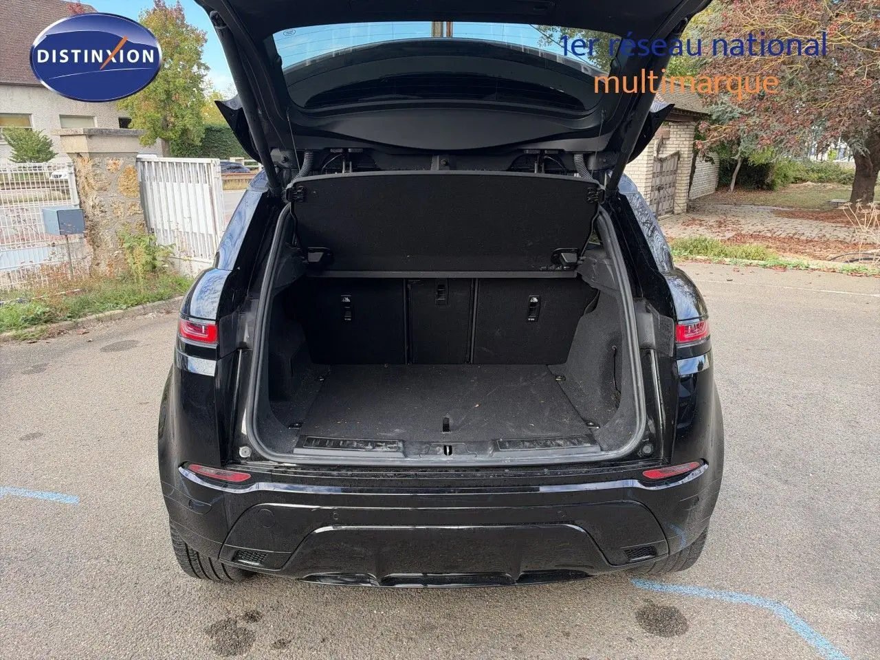 Vue arrière d'un Range Rover Evoque Santorini Black 2023 avec coffre ouvert et intérieur de coffre visible.