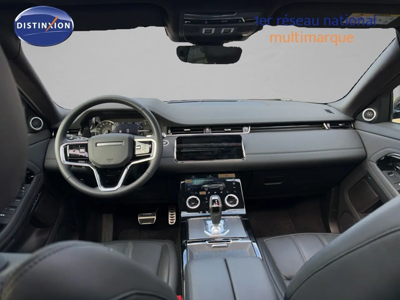 Vue intérieure avant du Range Rover Evoque 2023 en Santorini Black, avec tableau de bord moderne et console centrale tactile.