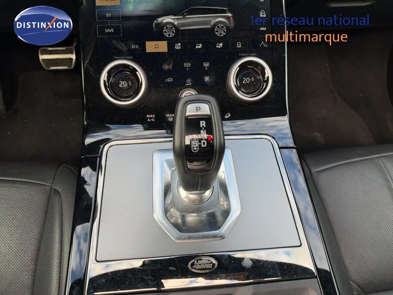 Vue rapprochée de la console centrale du Range Rover Evoque 2023 Santorini Black, avec levier de vitesses automatique et écran tactile.