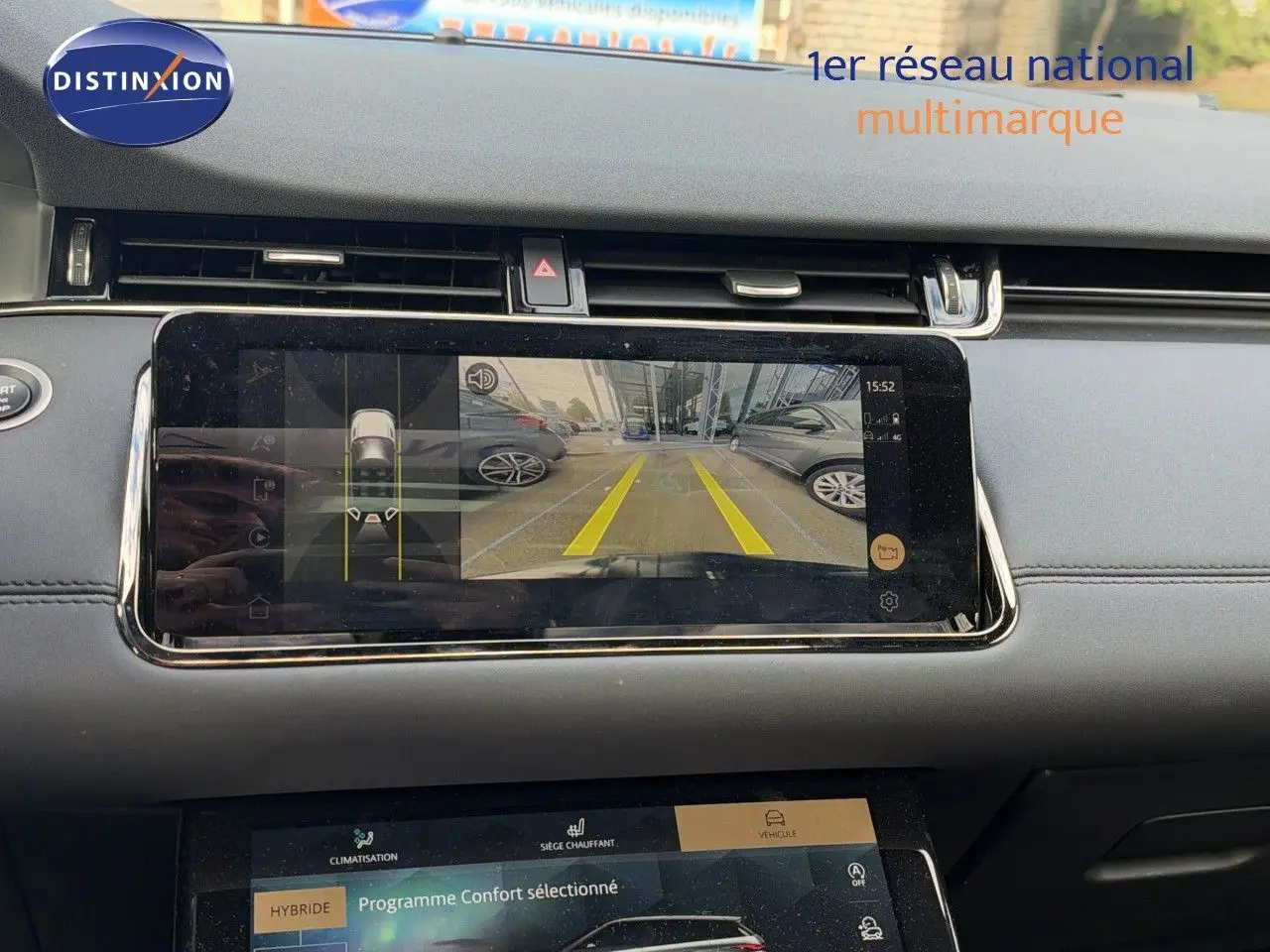 Vue intérieure du tableau de bord du Range Rover Evoque 2023 noir, avec écran affichant la caméra de recul et les réglages du programme confort hybride.