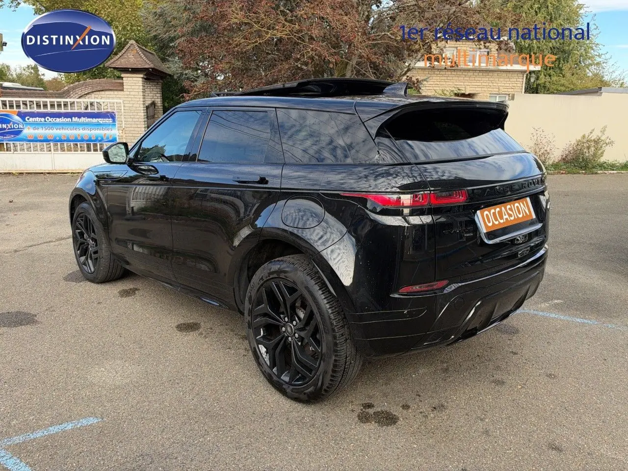 Vue 3/4 arrière d'un Range Rover Evoque P300e hybride rechargeable noir Santorini avec jantes noires et vitres teintées.
