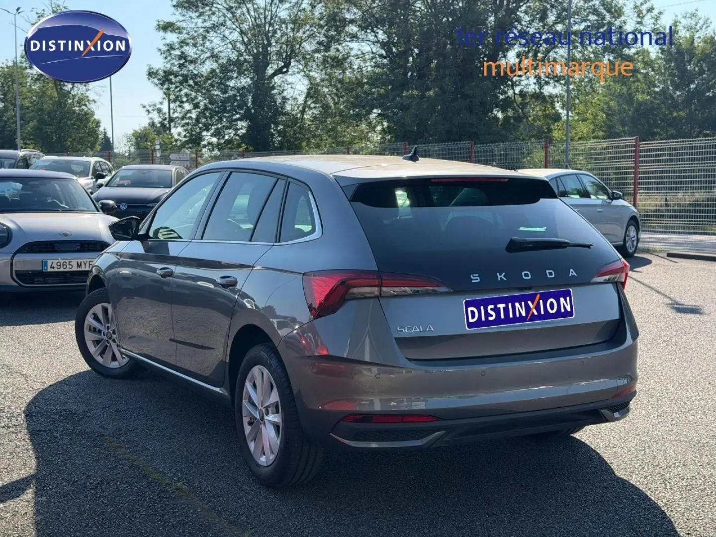 Vue 3/4 arrière droite d'une Skoda Scala gris métallisé avec feux arrière LED et jantes alu en parking extérieur.
