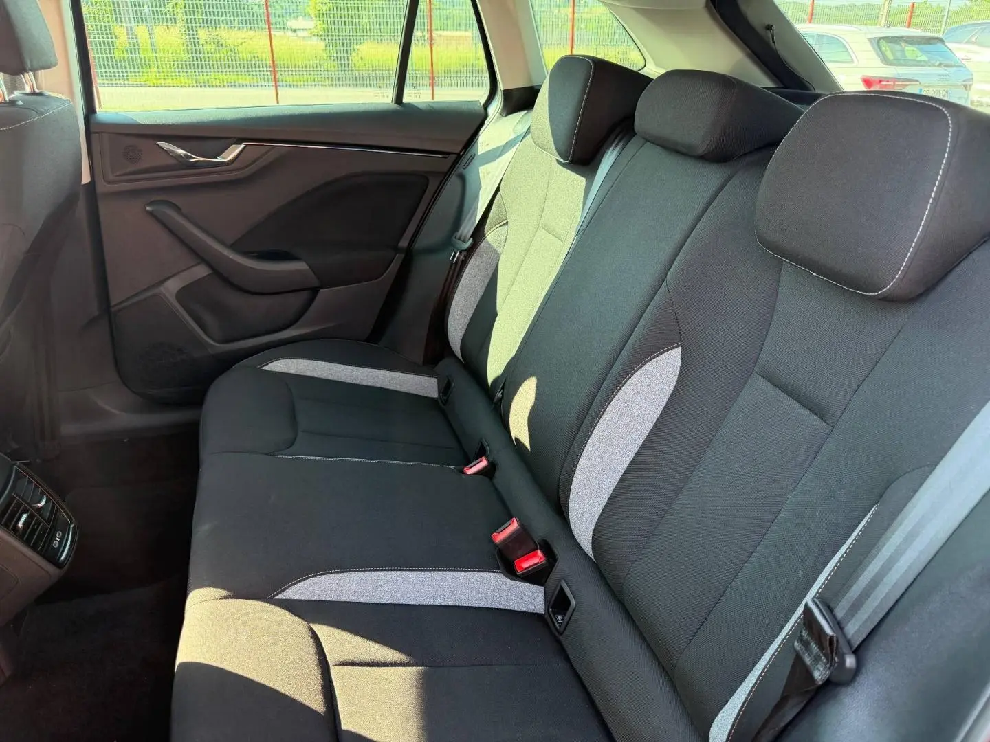 Vue latérale droite de la banquette arrière tissu noir et gris de la Skoda Scala 2025, avec ceintures et appuie-têtes.