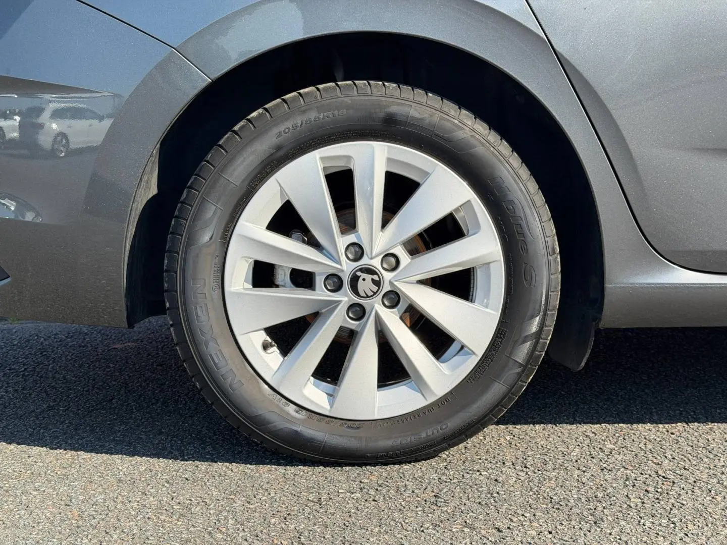 Gros plan sur la roue avant gauche grise d'une Skoda Scala 2025 avec jante alliage et logo au centre.
