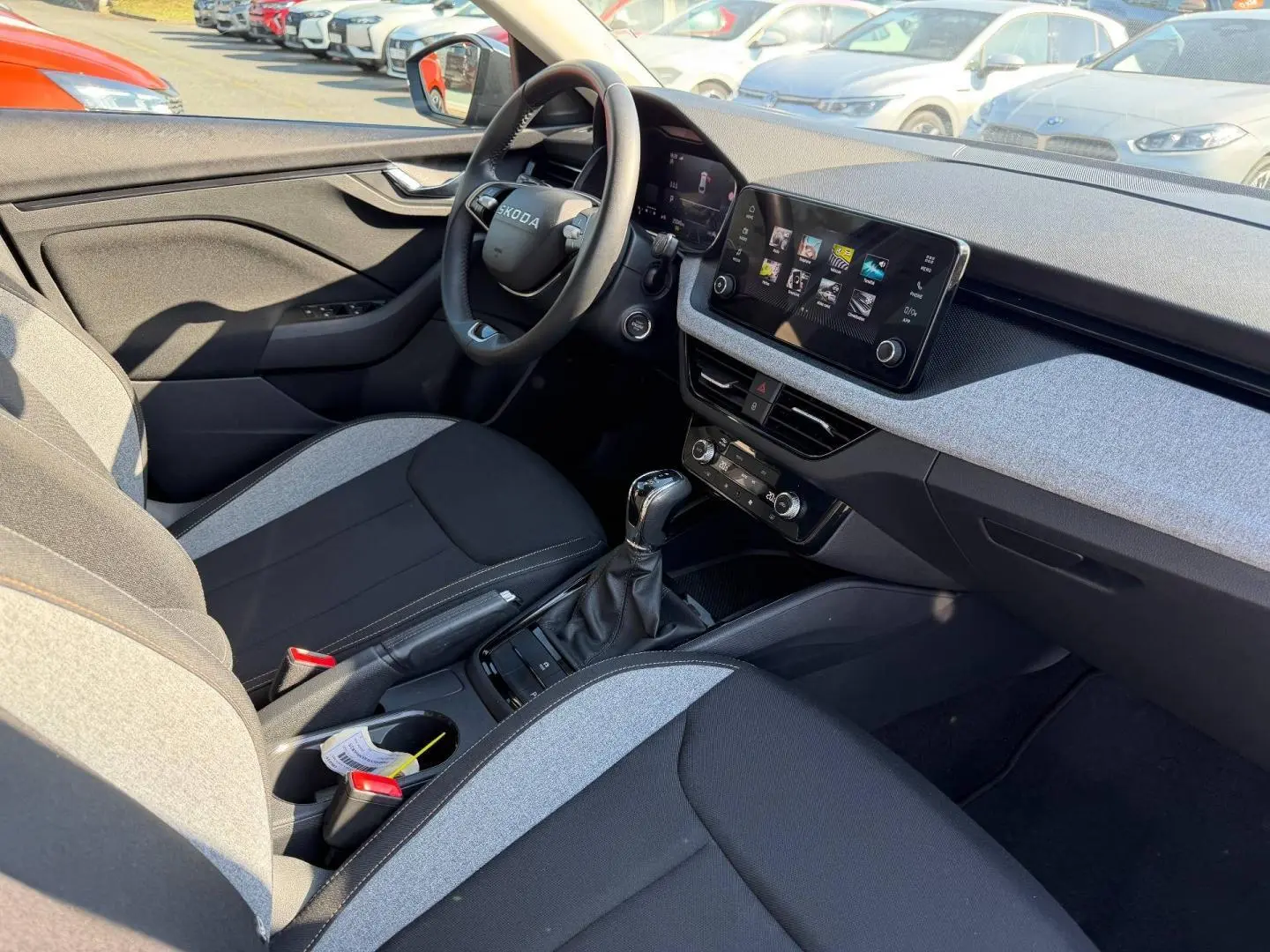 Intérieur avant droit de la Skoda Scala gris, volant cuir multifonction, écran tactile et sellerie bicolore noire et grise.