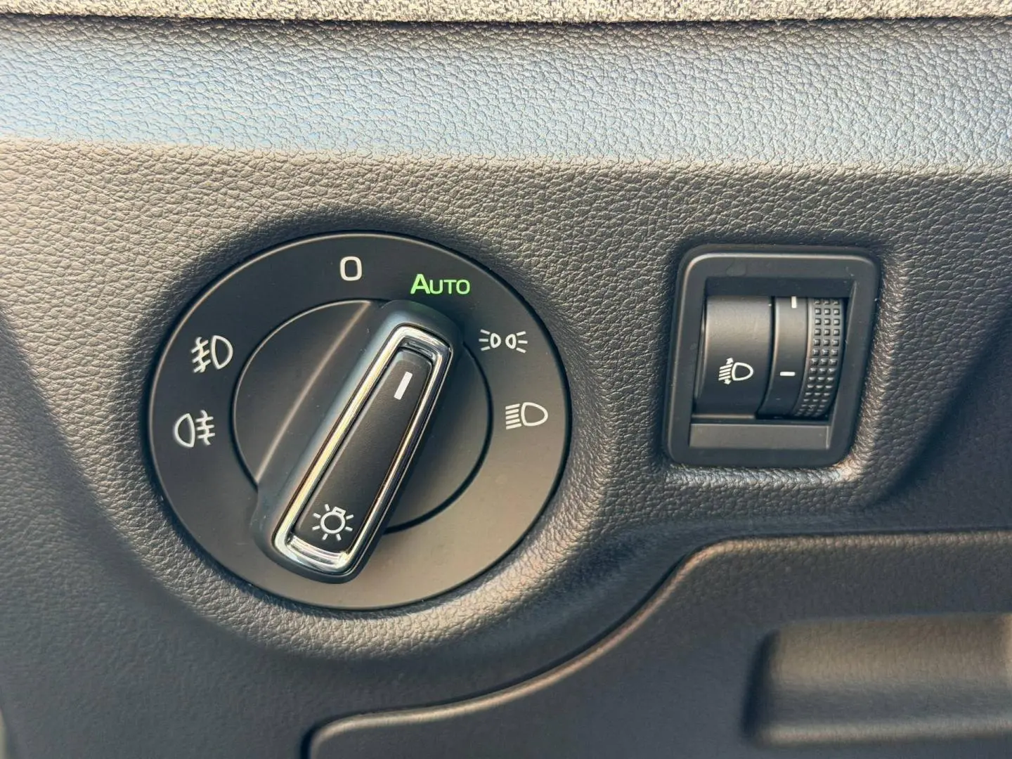 Gros plan sur les commandes d’éclairage intérieures du Skoda Scala 2025, avec bouton rotatif et réglage de hauteur des phares.
