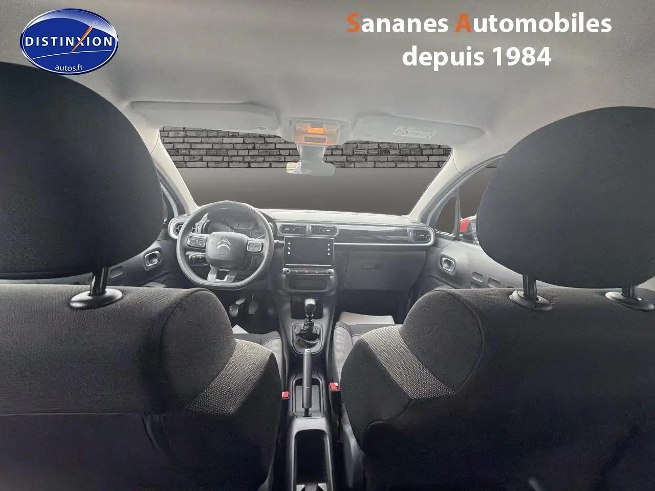 Vue intérieure avant de la Citroën C3 2021 avec tableau de bord moderne et sellerie tissu noire.