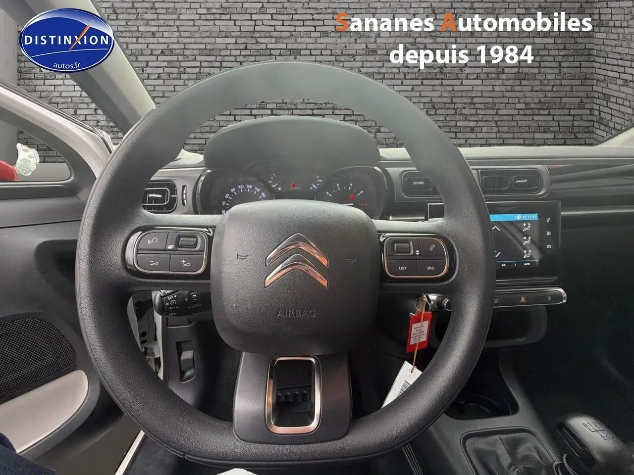 Vue centrée sur le volant Citroën C3 2021, tableau de bord et écran tactile avec commandes au volant visibles.