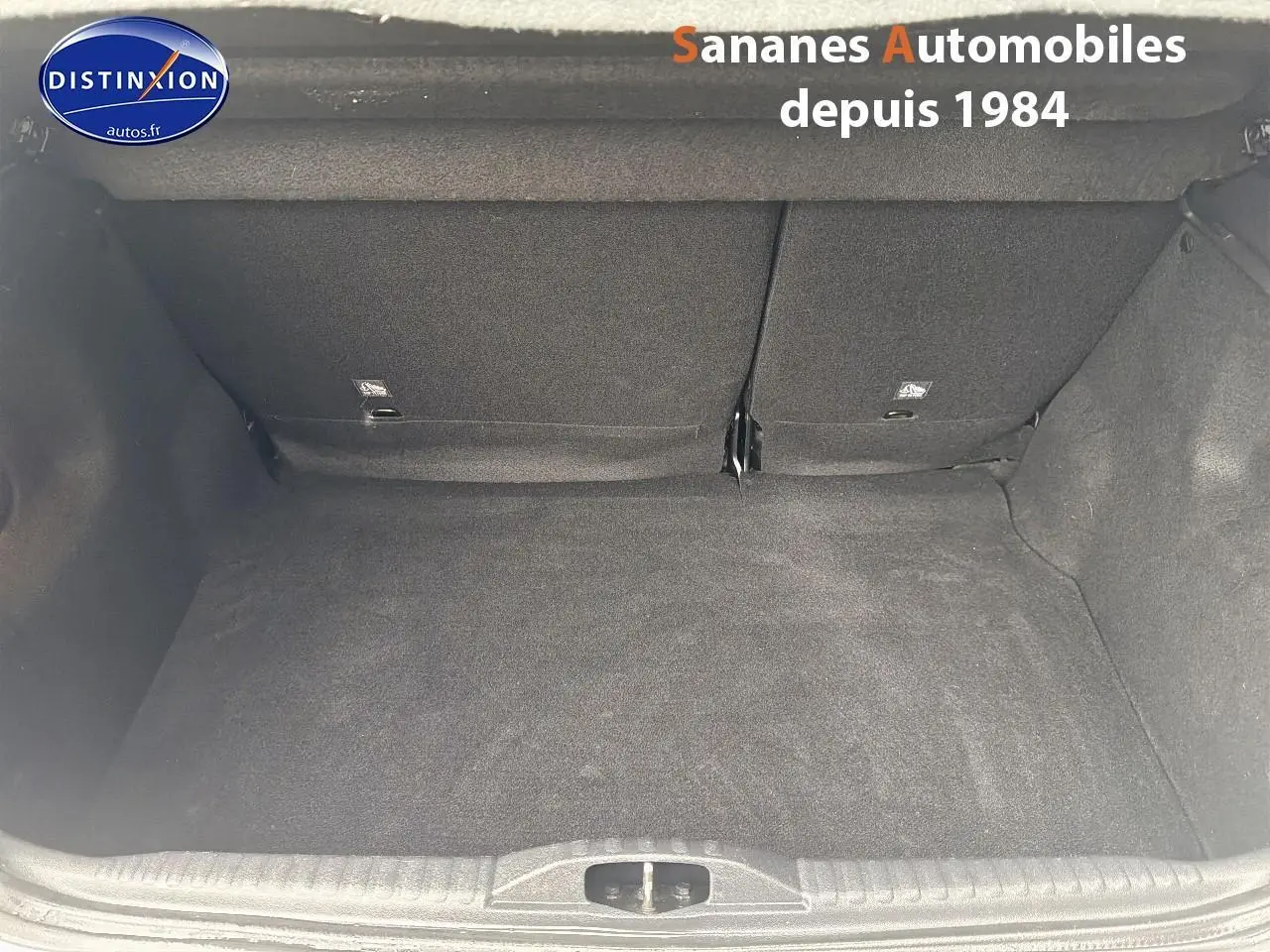 Coffre vide de Citroën C3 2021 blanc toit rouge, vue intérieure arrière avec banquette rabattue partiellement.
