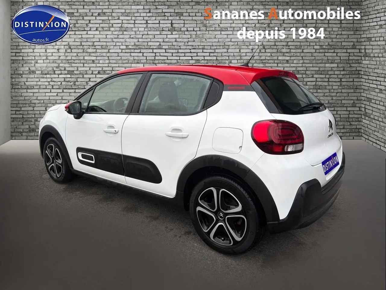 Citroën C3 2021 blanc avec toit rouge vue 3/4 arrière côté gauche, jantes noires et protections latérales noires.
