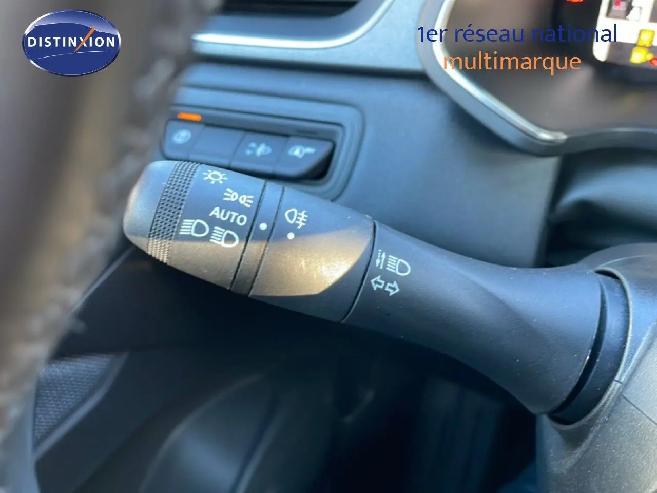 Gros plan sur la commande des phares et clignotants à gauche du volant dans l'habitacle du Renault Captur 2025.