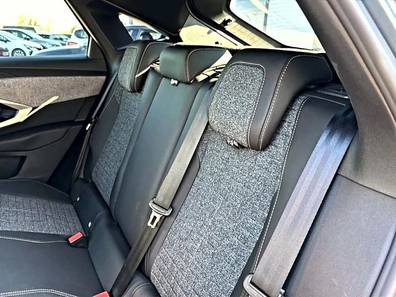 Vue rapprochée de la banquette arrière en tissu gris et cuir noir du Peugeot 3008 1.2 Hybrid 145 Allure 2025.
