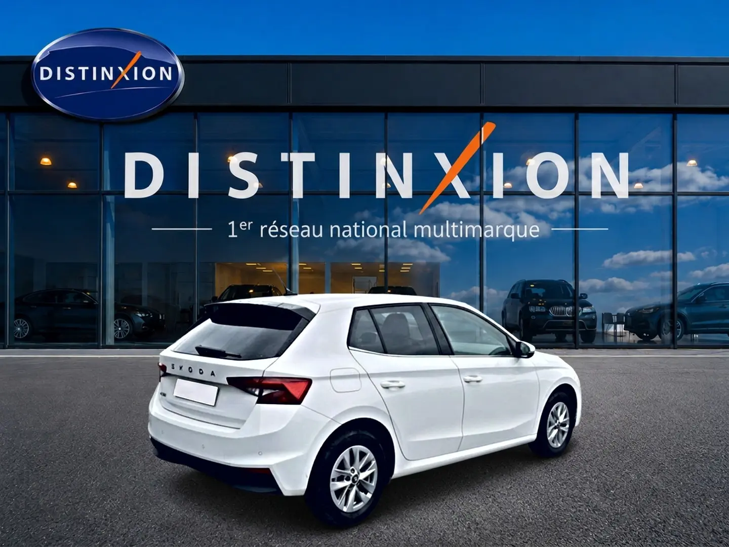 Vue 3/4 arrière droite d'une Skoda Fabia blanche 2025 avec jantes alliage devant une vitrine Distinxion.