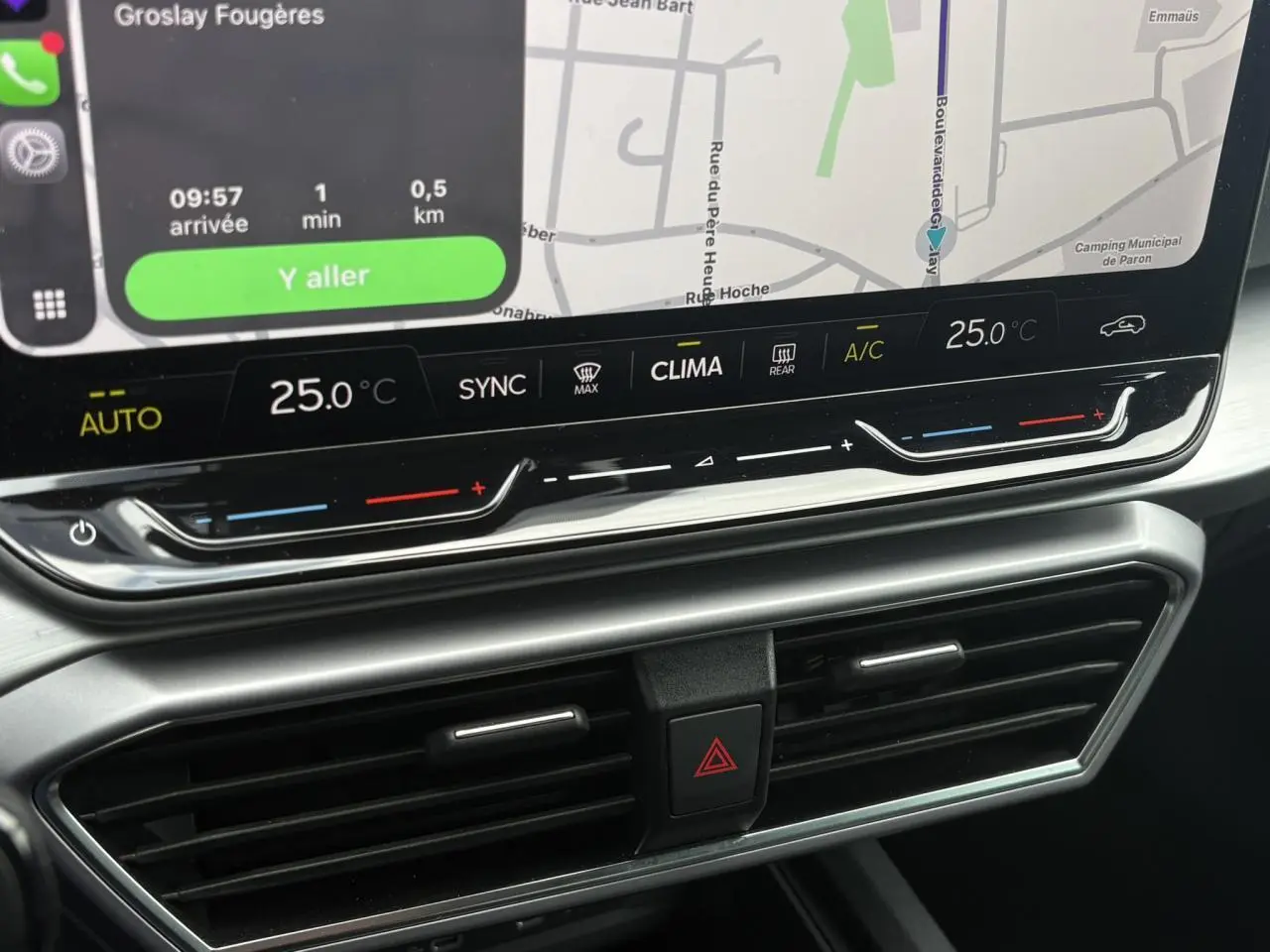 Gros plan sur la console centrale du SEAT LEON 2025, affichage tactile avec commandes climatisation et ventilation.