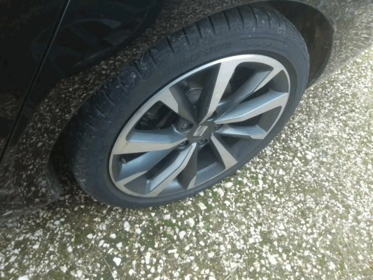 Gros plan sur la jante alliage 18 pouces de la SEAT LEON ST noire Minuit, vue côté droit arrière.