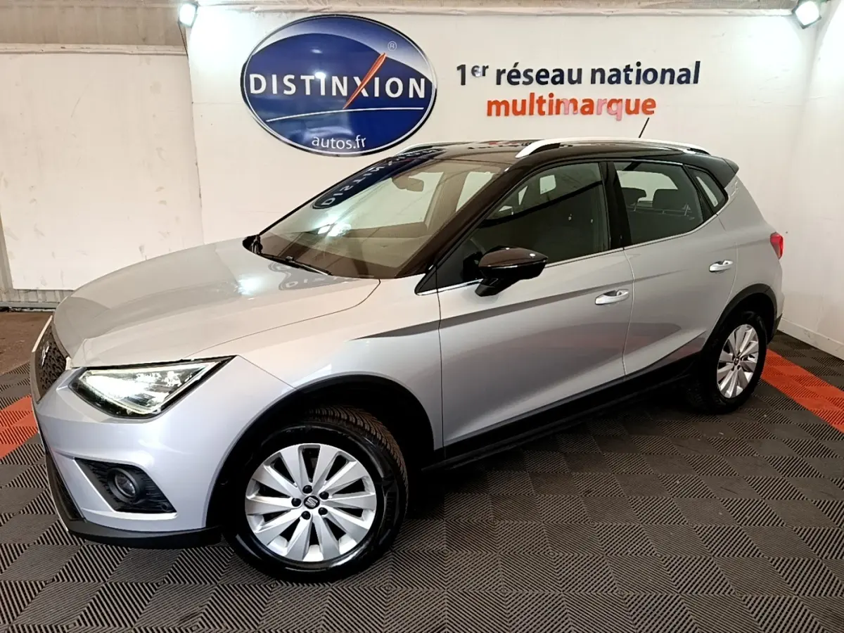 SEAT Arona gris clair vue 3/4 avant droit en intérieur, avec toit noir et jantes alliage.