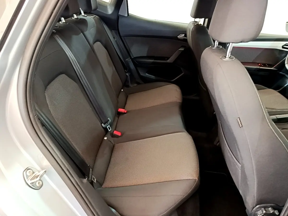 Vue intérieure côté gauche sur la banquette arrière grise du SEAT Arona 2019 avec sièges tissu et ceintures visibles.