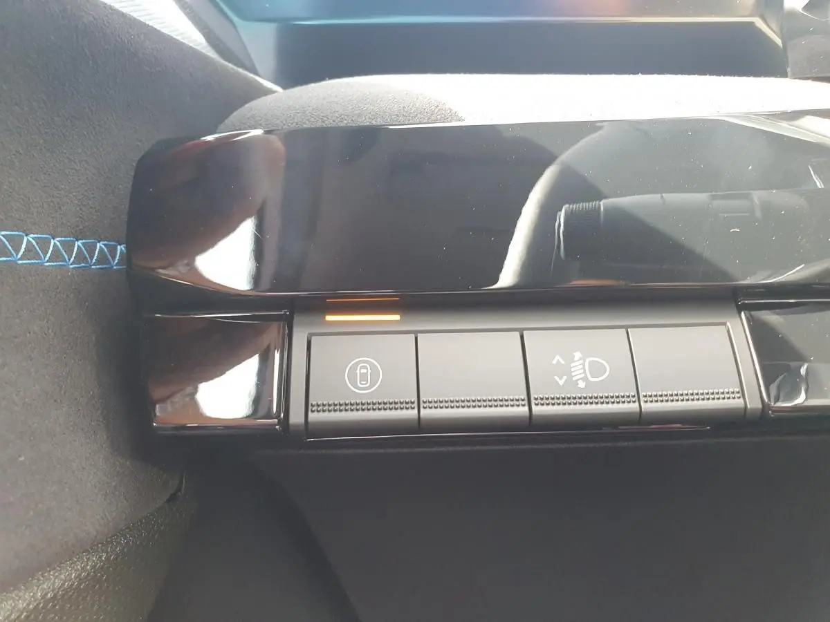 Détail des commandes d’éclairage et verrouillage sur la console intérieure noire de la Renault Clio VI hybride.