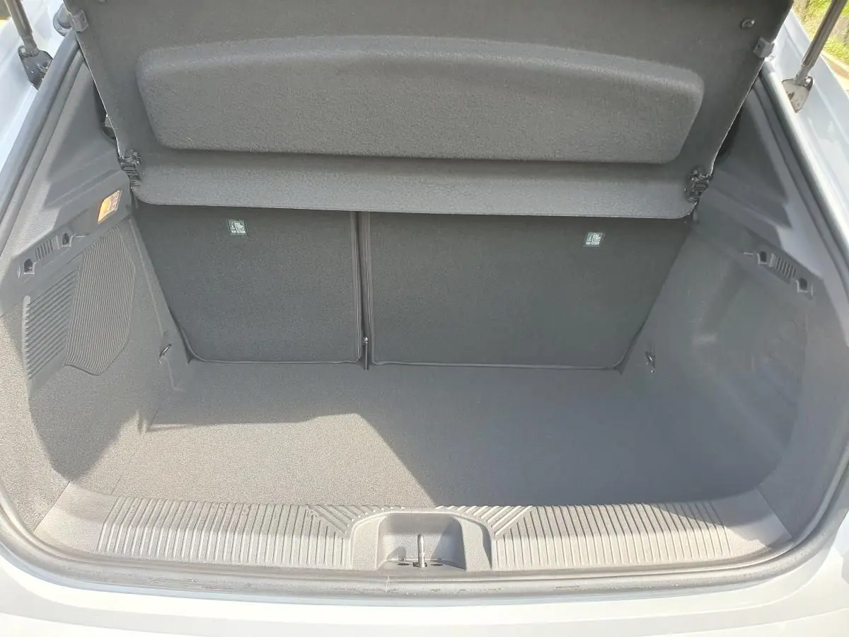 Coffre ouvert vu de l'arrière d'une Renault Clio VI gris Rafale, montrant un espace de chargement vide et propre.