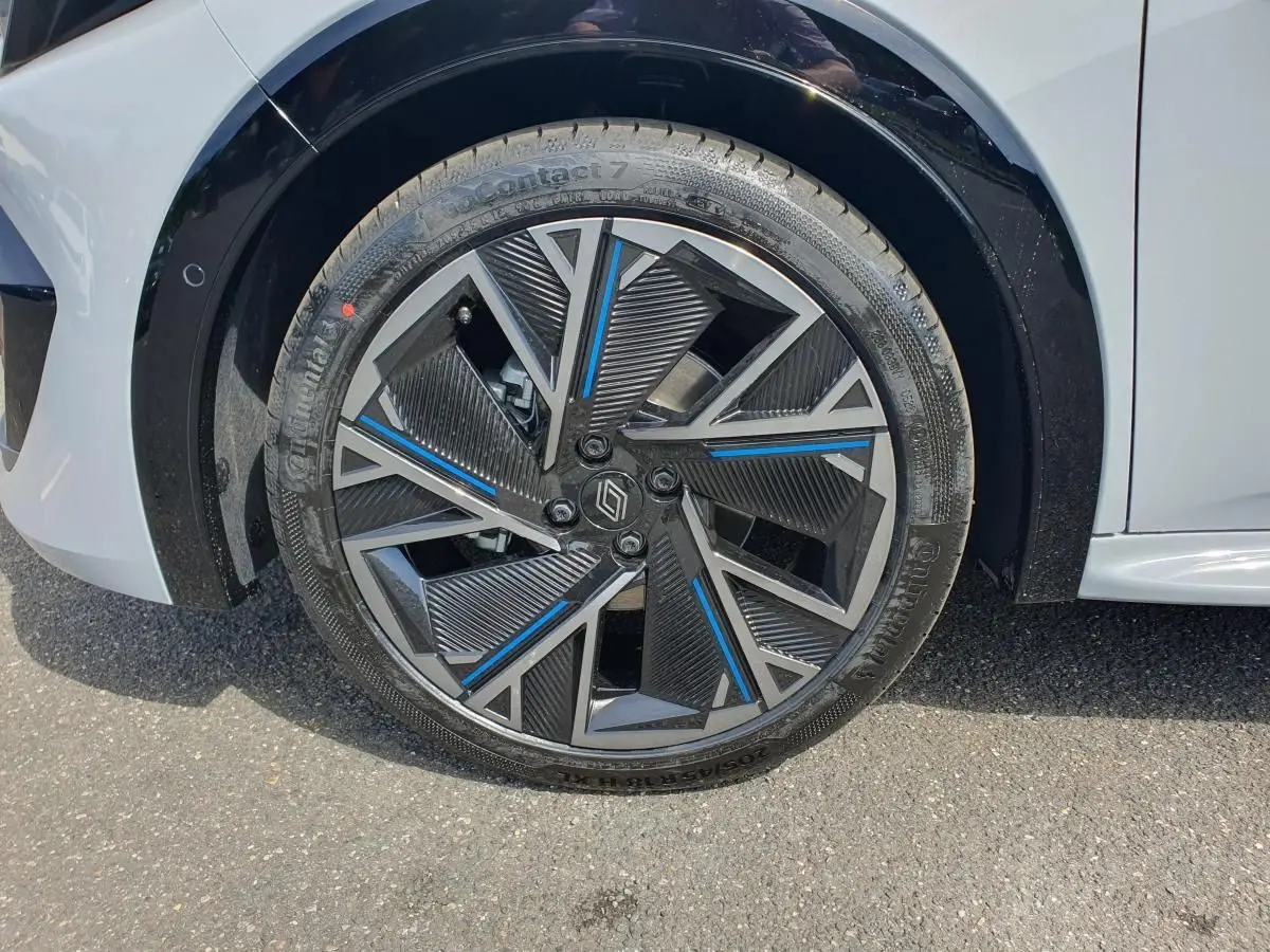 Gros plan sur la jante alliage 18” diamantée noire et bleue du côté avant droit de la Renault Clio VI gris Rafale.