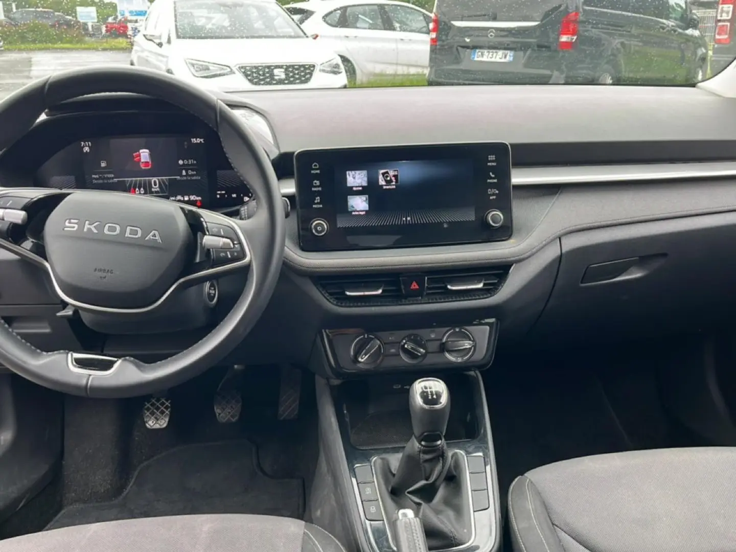 Intérieur avant de la Skoda Fabia noire 2025, vue centrée sur le volant cuir et la console avec écran tactile.