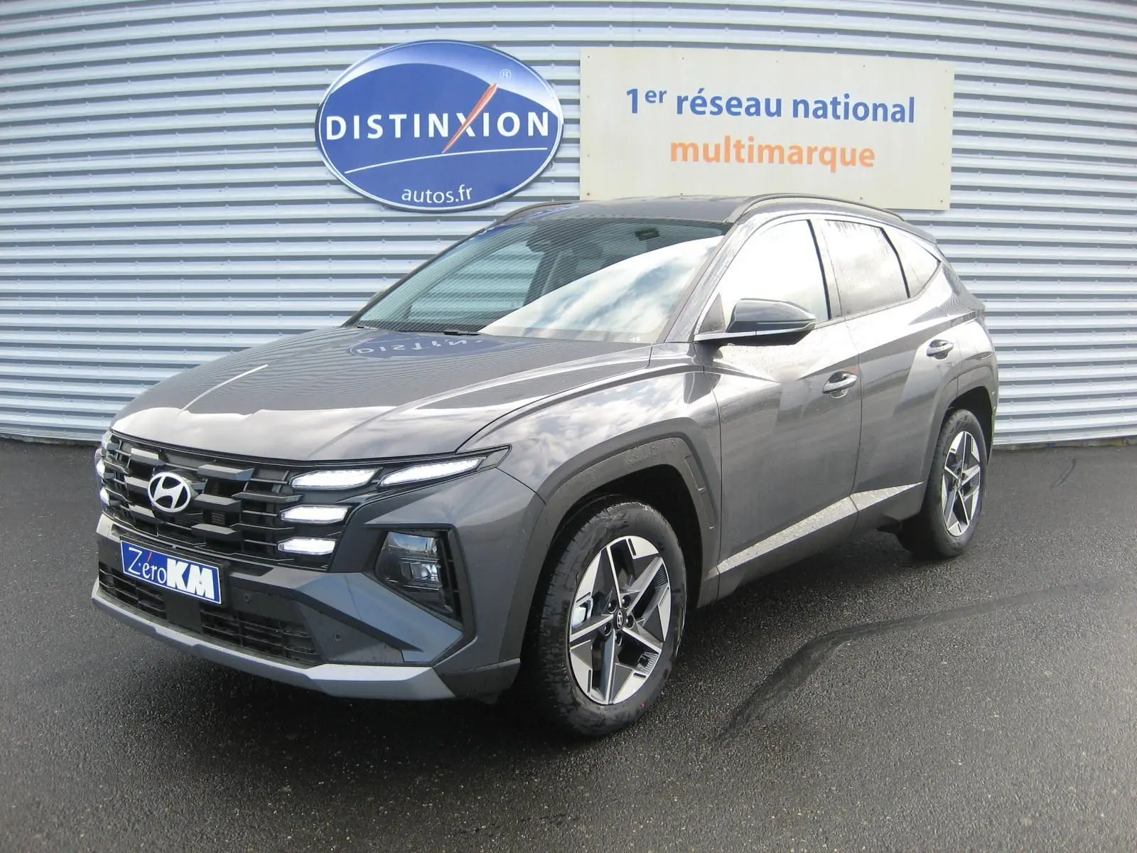 Hyundai Tucson IV PH.2 Style gris Ecotronic en vue 3/4 avant droit, avec calandre distinctive et jantes alliage.