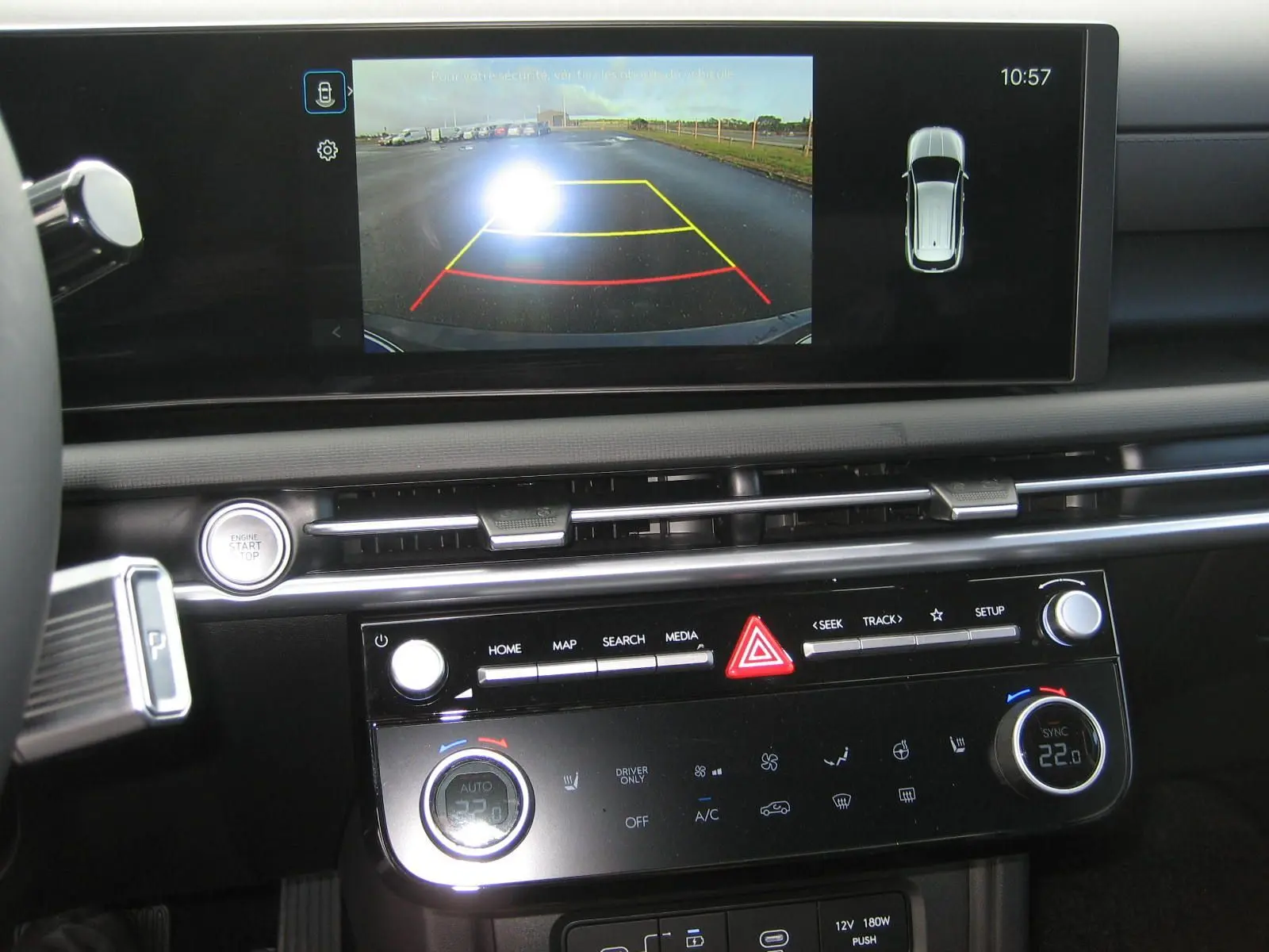 Vue rapprochée de l'écran central et de la console du Hyundai Tucson 2025, affichant la caméra de recul et les commandes climatisation.