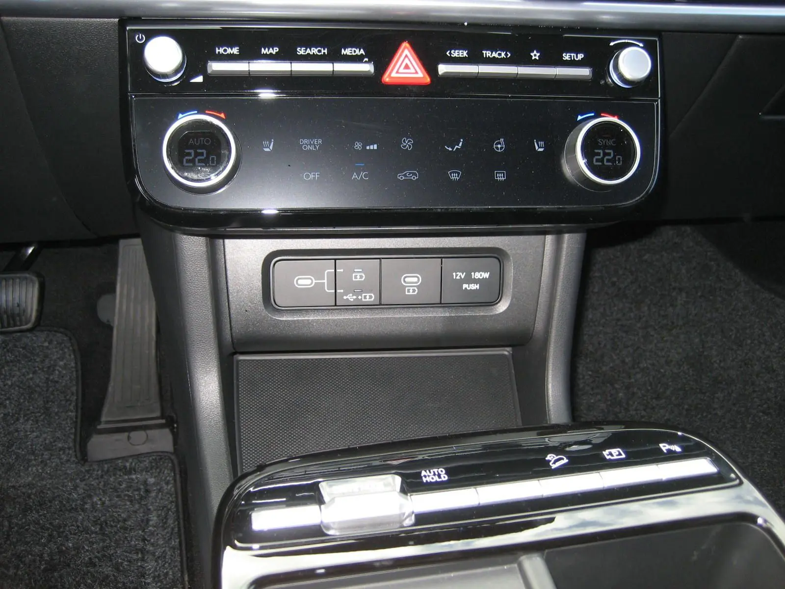 Gros plan sur la console centrale du Hyundai Tucson 2025, avec commandes climatisation et boutons de fonctions électroniques.