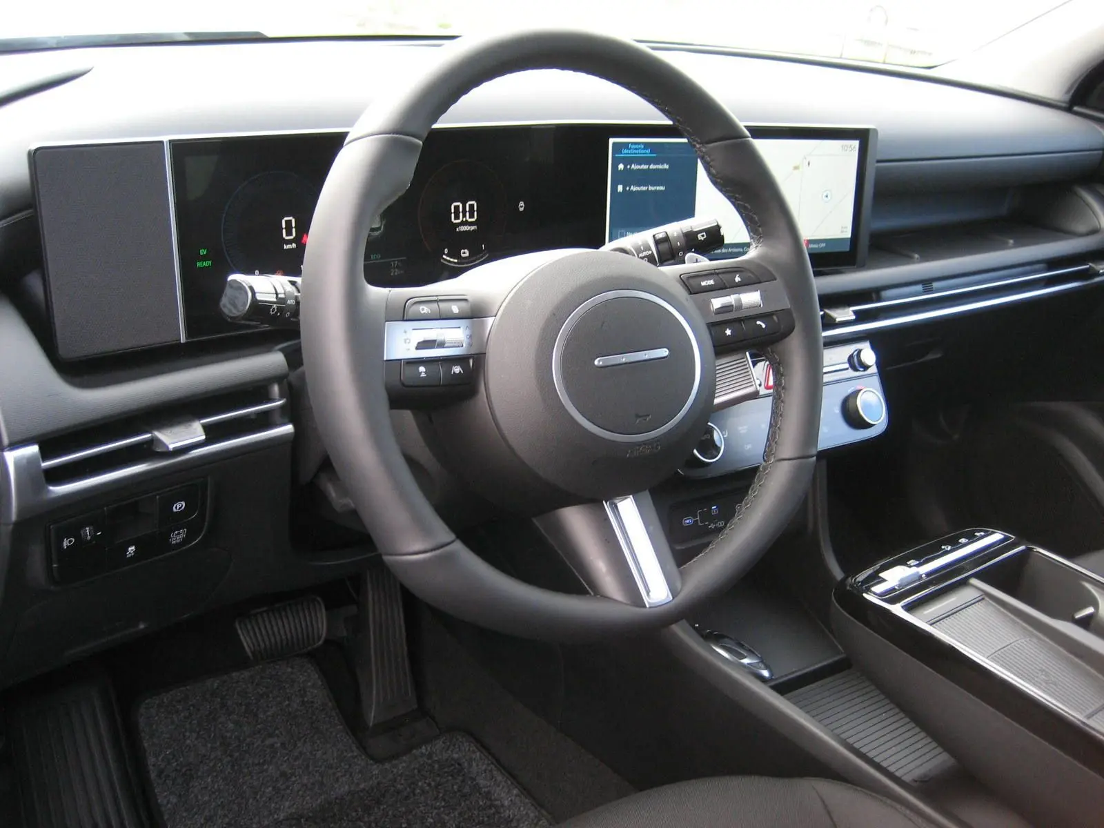 Vue intérieure du tableau de bord et volant du Hyundai Tucson 2025, avec écran digital large et commandes intégrées au volant.