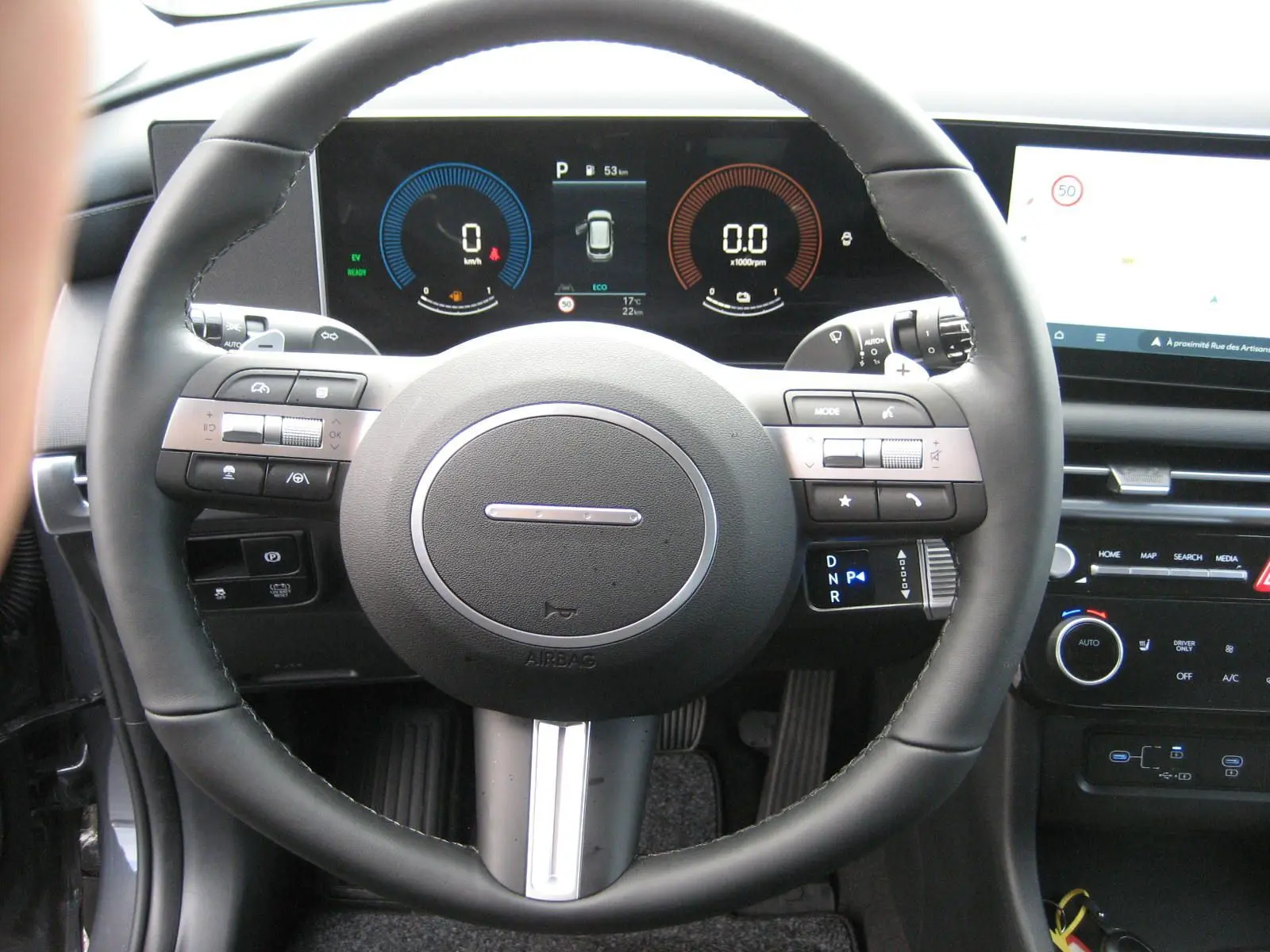 Vue rapprochée du volant multifonction et du tableau de bord numérique du Hyundai Tucson 2025 gris Ecotronic.