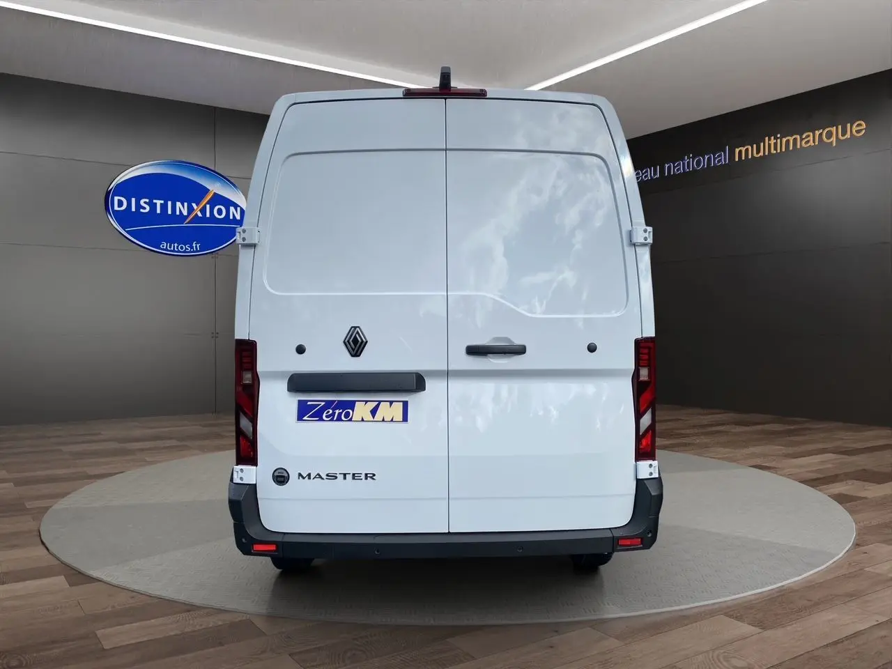 Vue arrière d’un Renault Master blanc 2025 avec portes battantes et logo distinctif sur fond de showroom.