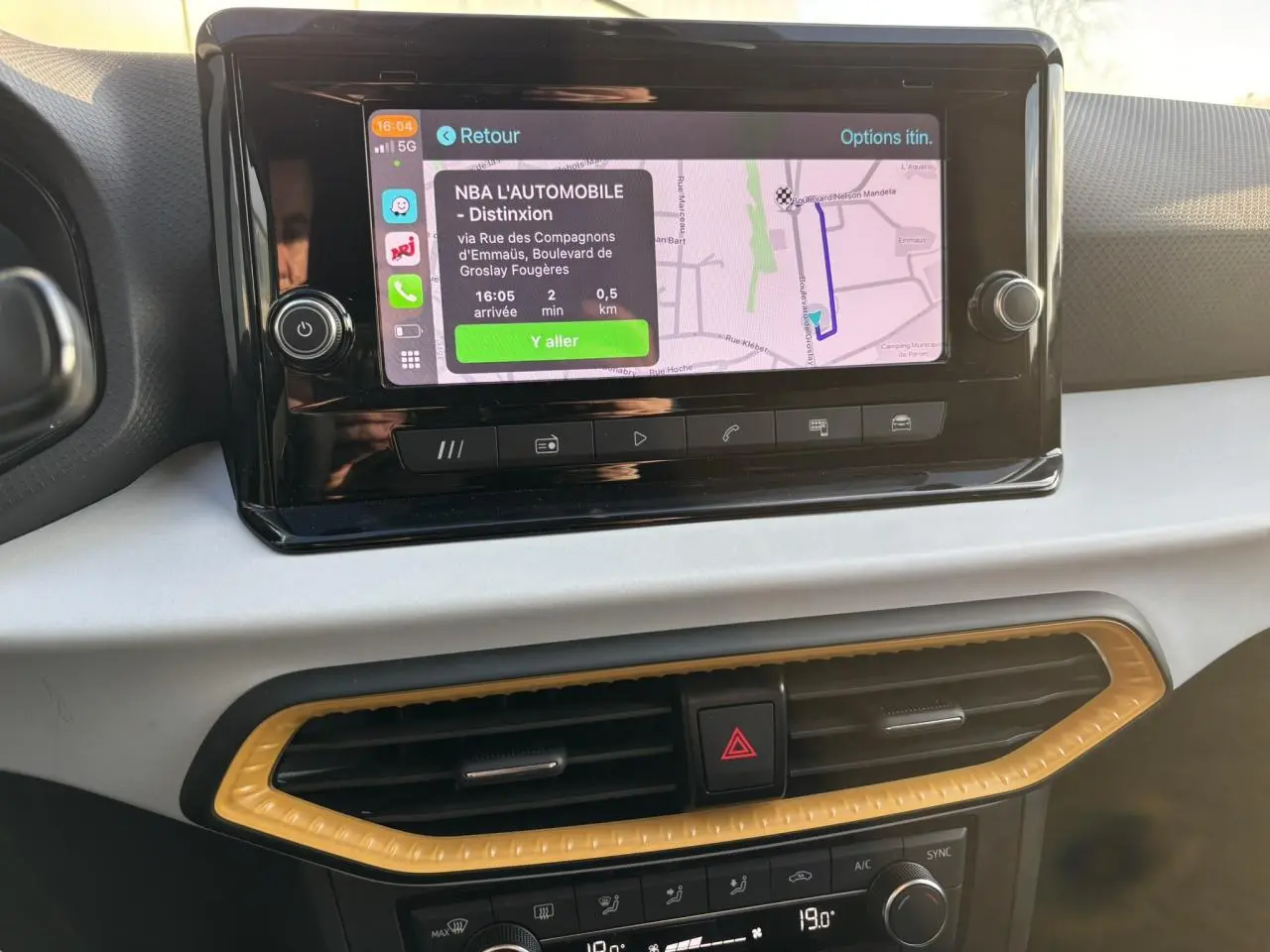 Vue rapprochée de l’écran tactile central et de la console de climatisation du SEAT Arona blanc, intérieur moderne.