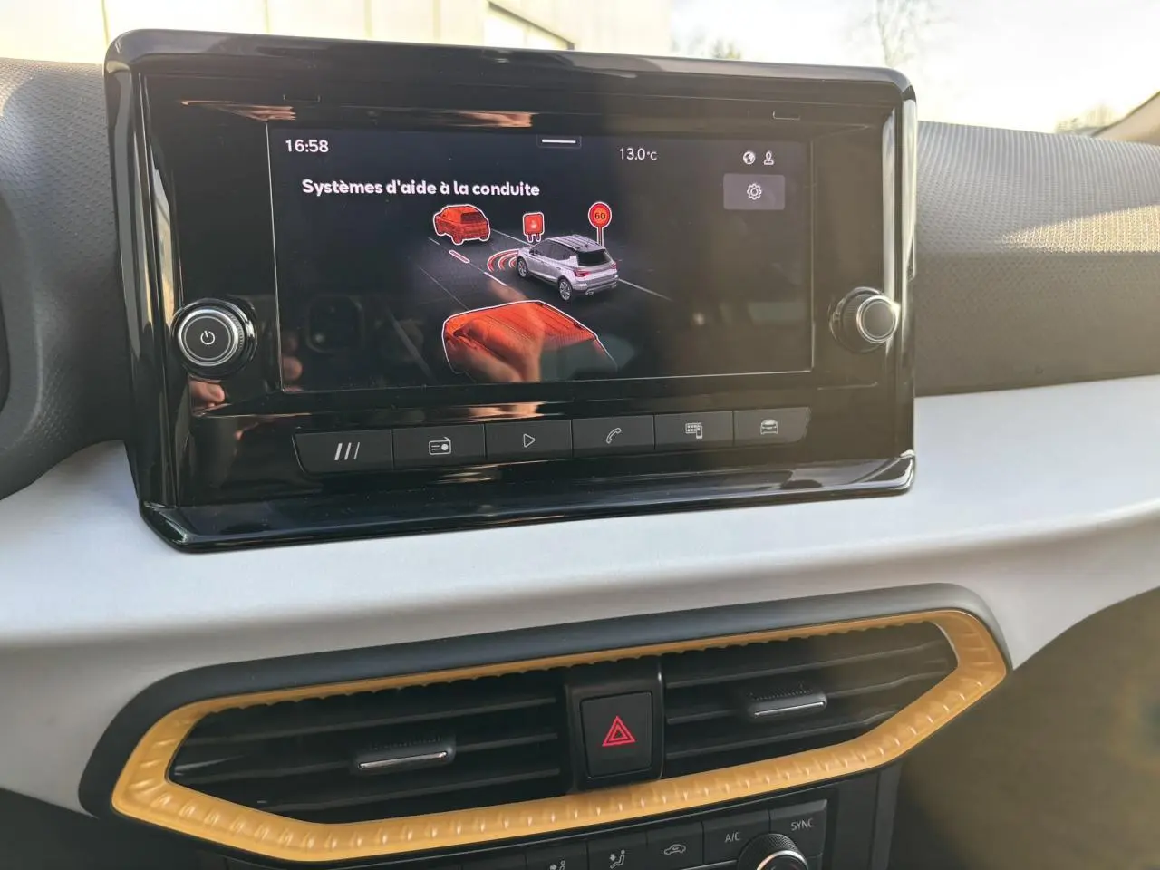 Vue rapprochée de l’écran tactile central du tableau de bord du SEAT Arona 2025 avec affichage des aides à la conduite.