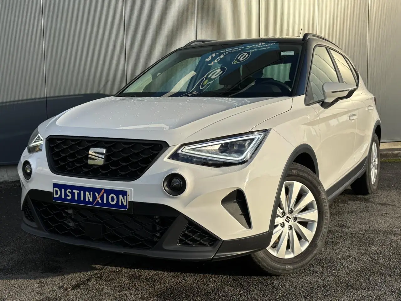 SEAT Arona blanc en 3/4 avant droit, avec calandre noire et jantes alliage 16 pouces visibles.