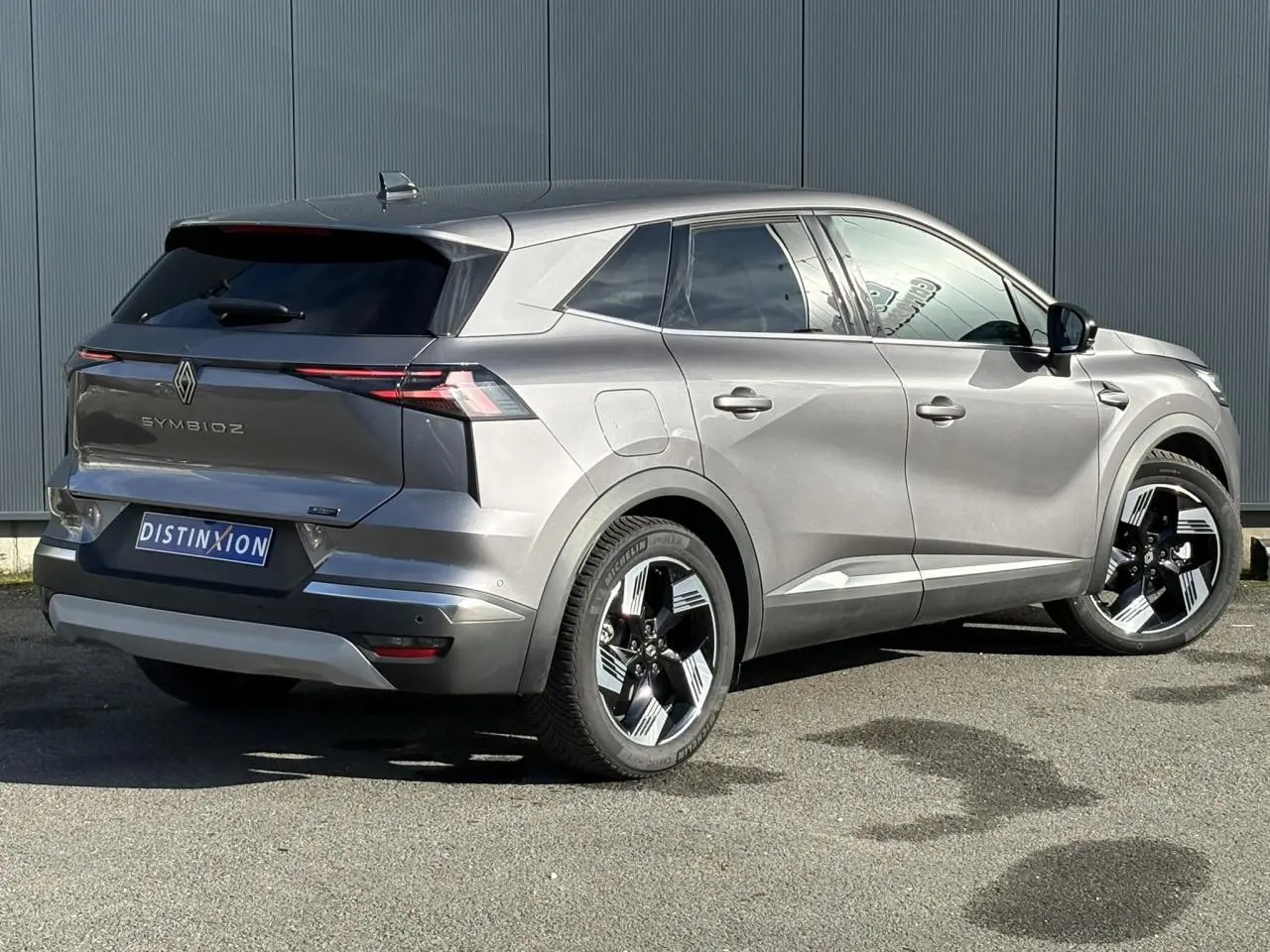 Vue 3/4 arrière droite d'un Renault Symbioz gris Cassiopée avec jantes 18 pouces et hayon mains libres.