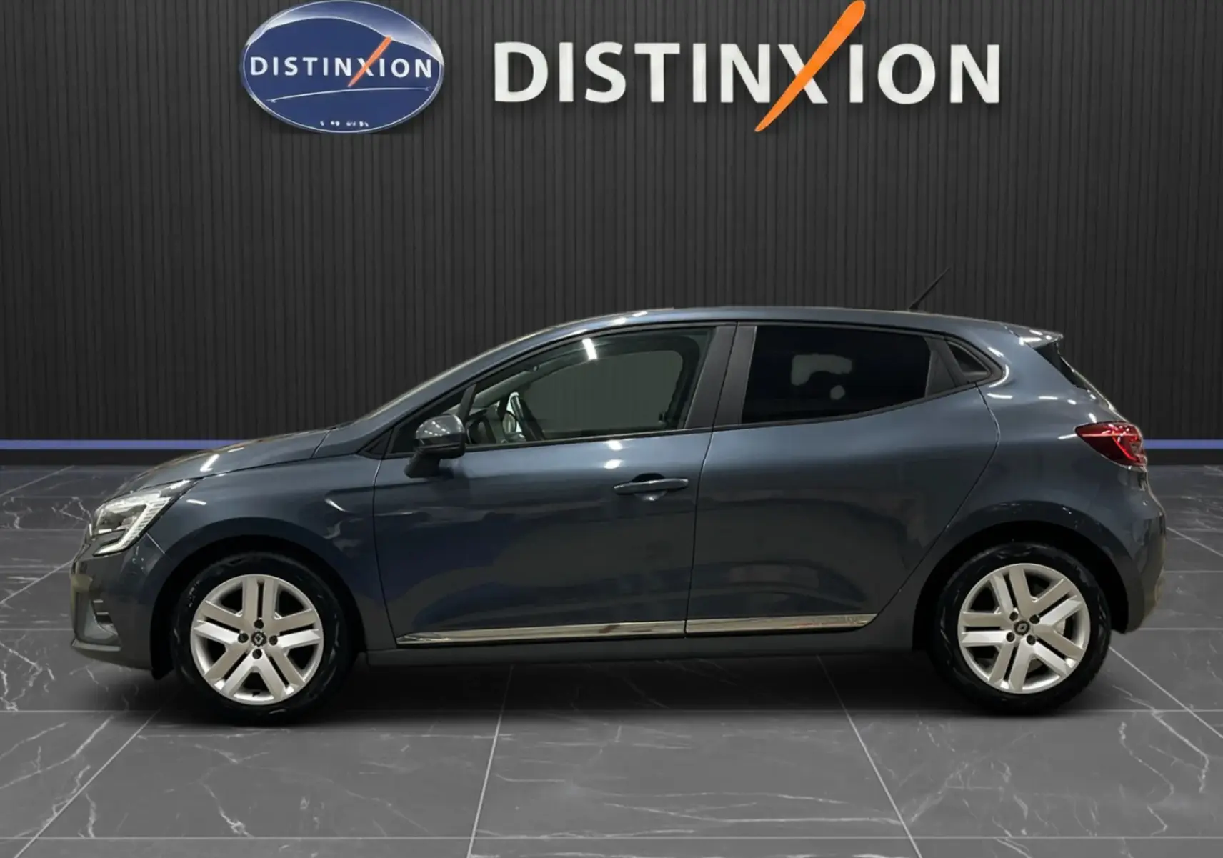 Profil côté gauche de la Renault Clio V Business gris titanium 2019, avec jantes alliage et vitres teintées.