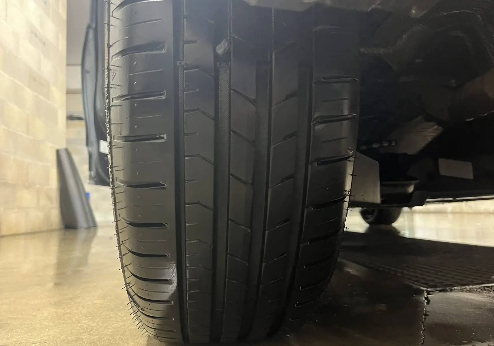 Gros plan sur le pneu avant droit d'une Renault Clio V gris titanium, montrant le profil et la bande de roulement.