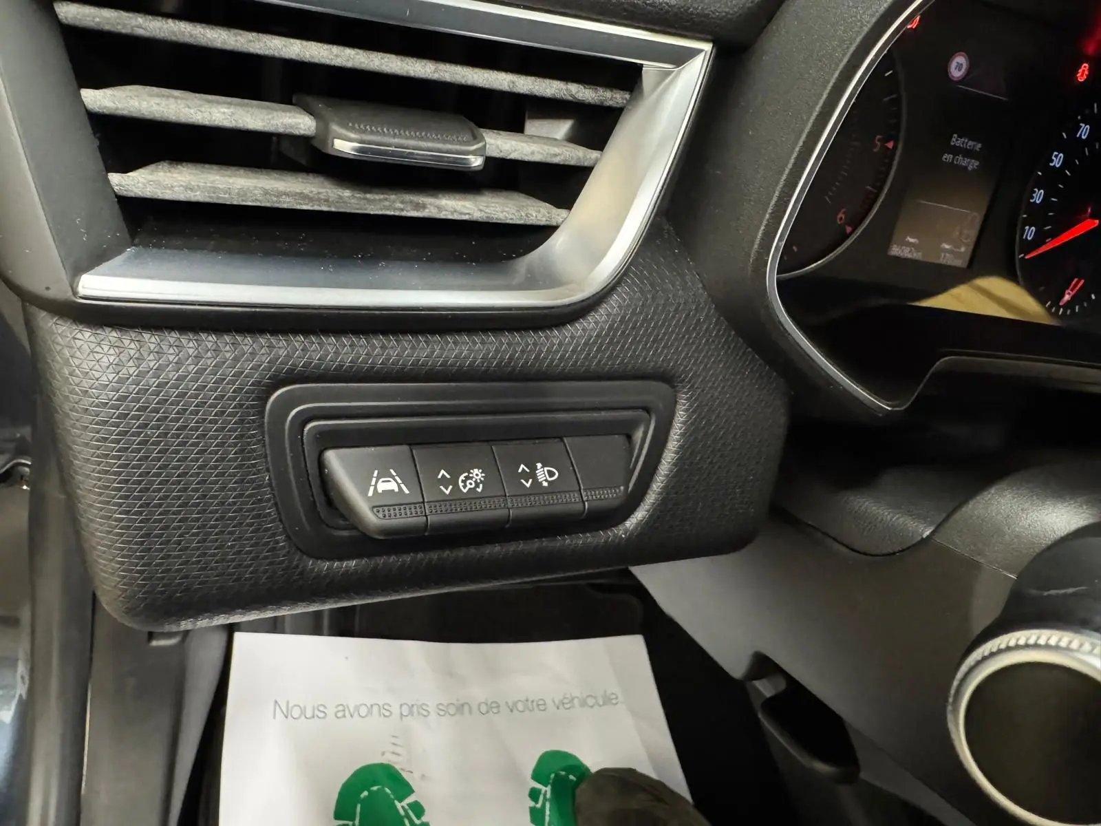 Détail intérieur côté gauche du tableau de bord de la Renault Clio V Business 2019, boutons de réglage et ventilation noire.