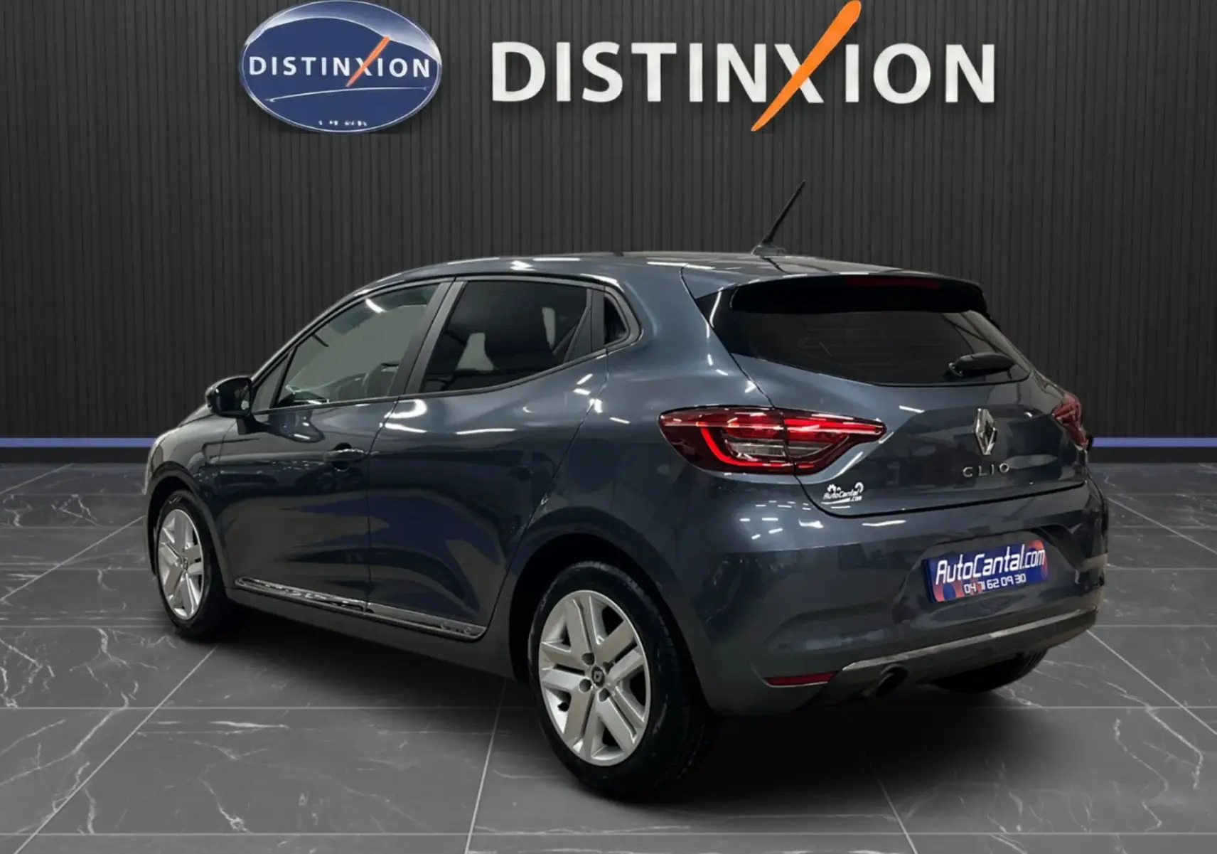 Renault Clio V Business gris titanium vue 3/4 arrière droit, avec feux arrière allumés et jantes alliage.