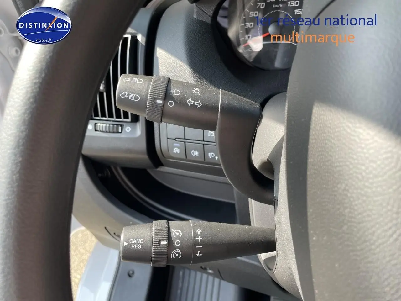 Gros plan sur les commandes au volant du Peugeot Boxer Fourgon blanc, côté gauche du poste de conduite.