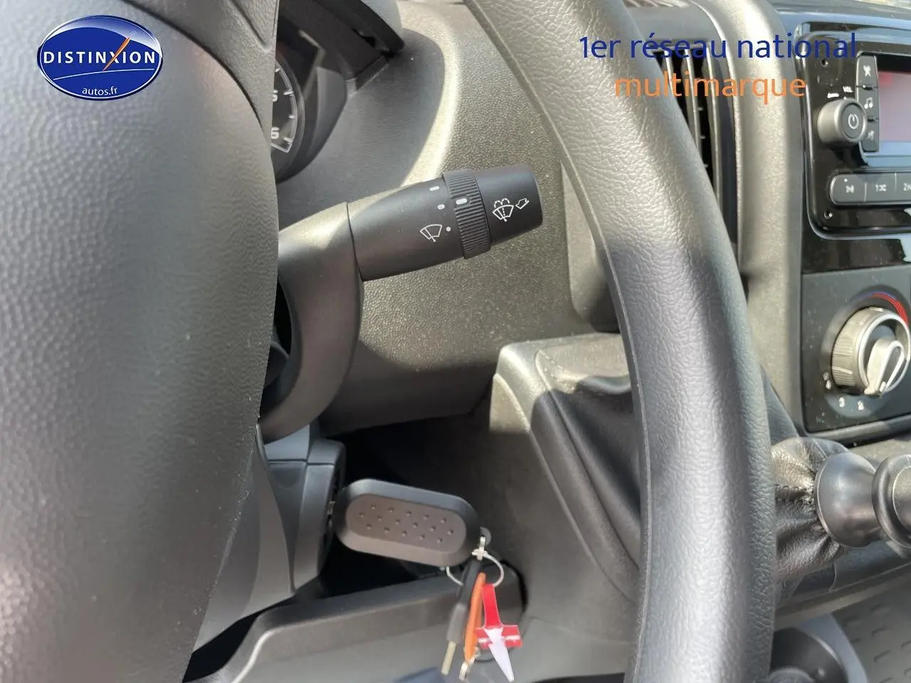 Vue rapprochée de l'intérieur côté conducteur du Peugeot Boxer Fourgon 2023, volant et commandes visibles en noir.