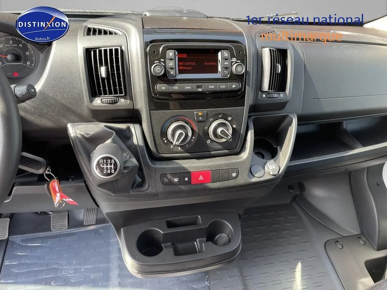 Vue intérieure du tableau de bord du Peugeot Boxer Fourgon 2023, avec levier de vitesses manuel et commandes centrales visibles.