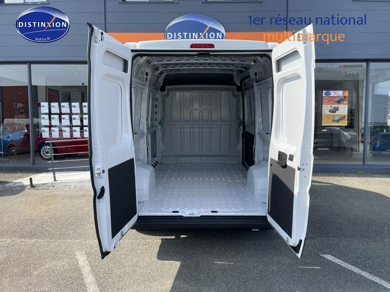 Vue arrière du Peugeot Boxer Fourgon blanc 2023 avec portes ouvertes montrant la grande zone de chargement vide.