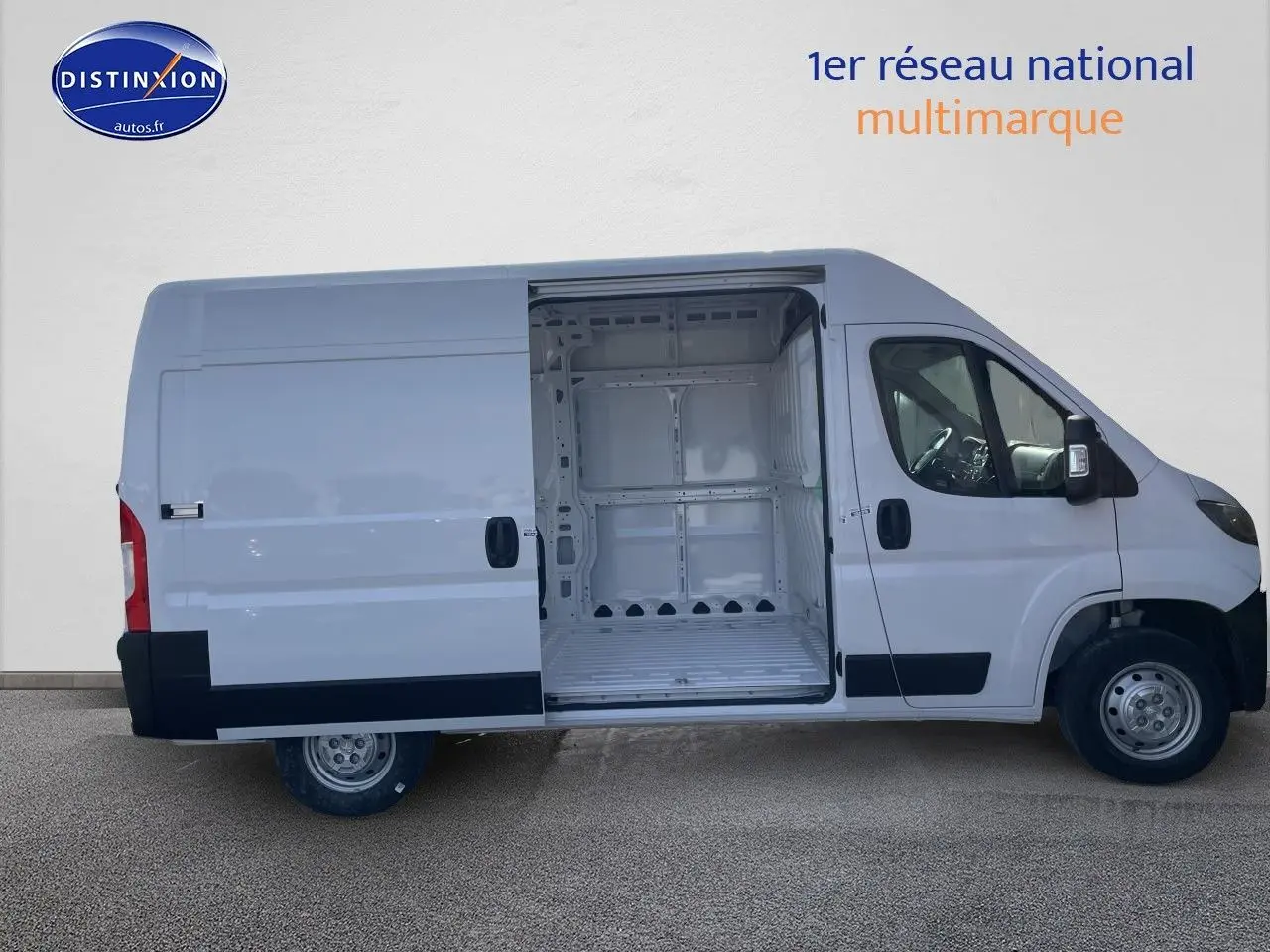 Vue latérale gauche d’un Peugeot Boxer blanc 2023 avec porte coulissante ouverte dévoilant l’espace de chargement vide.